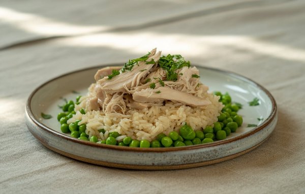Shredded leftover chicken served over rice with green peas for a simple, filling meal.